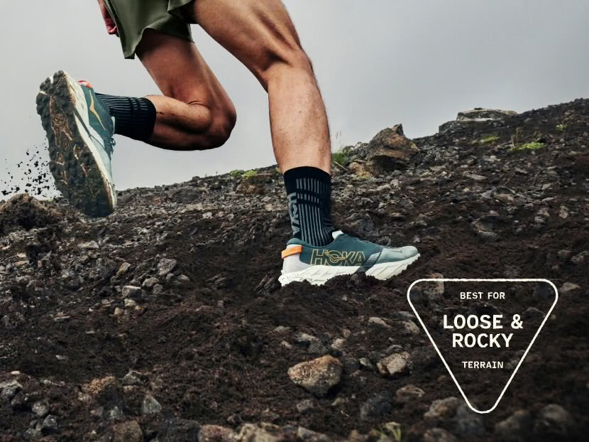 Runner wearing HOKA Speedgoat 7 on loose rocky trail terrain product detail
